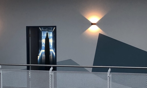 Modern Wand mit einer Tür, die futuristische Beleuchtung und geometrische Formen zeigt.